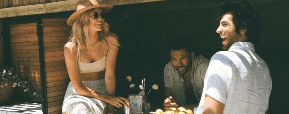 Friends sharing Tinto natural wine at a sunlit table